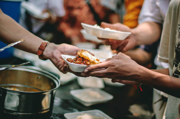 Volunteers serving guests through a Catholic Charities soup kitchen